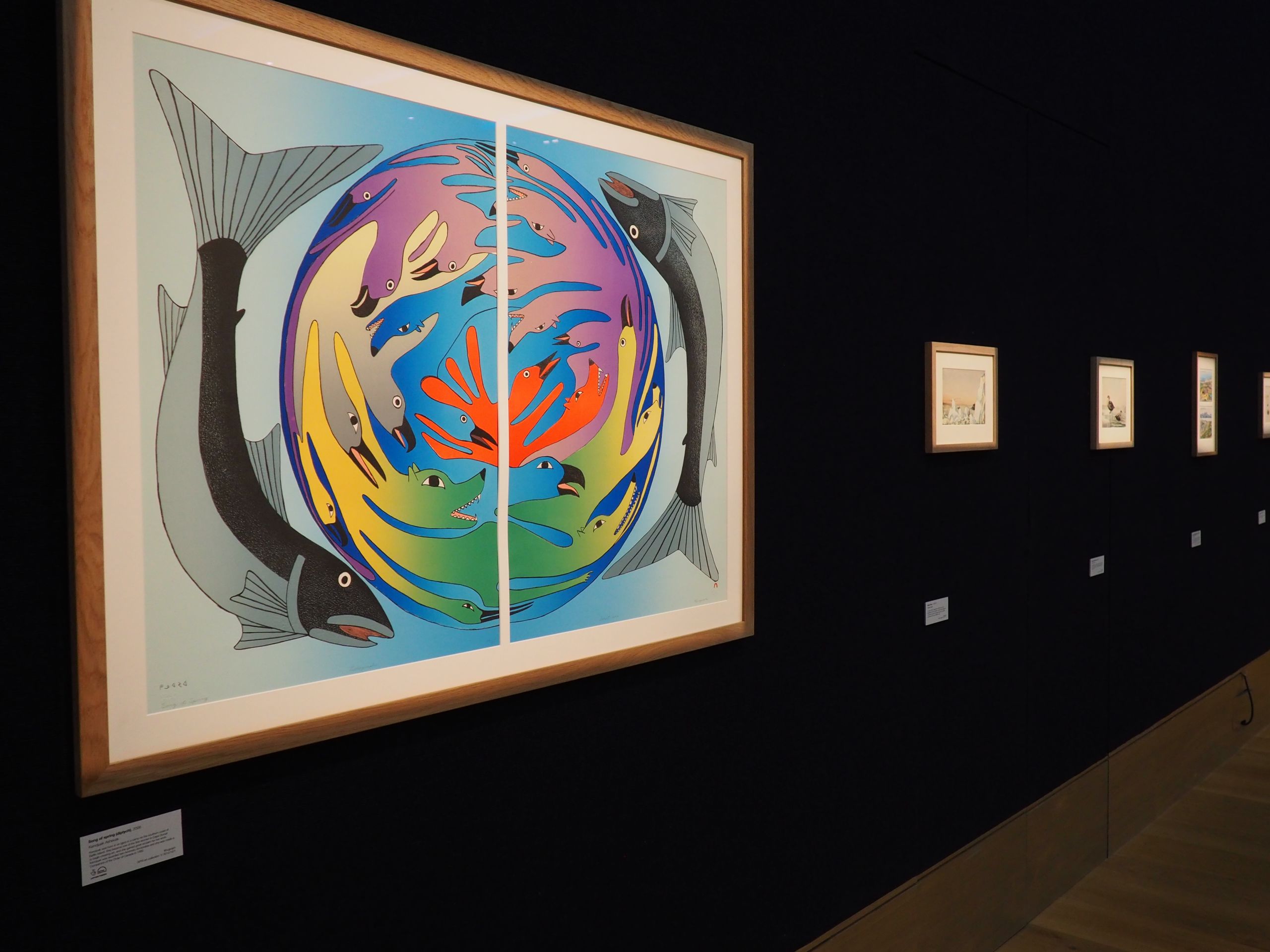 A colourful artwork featuring fish and other creatures displayed in a gallery