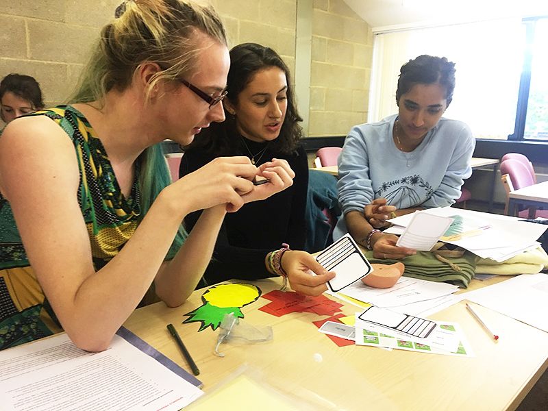 Three students look at teaching materials