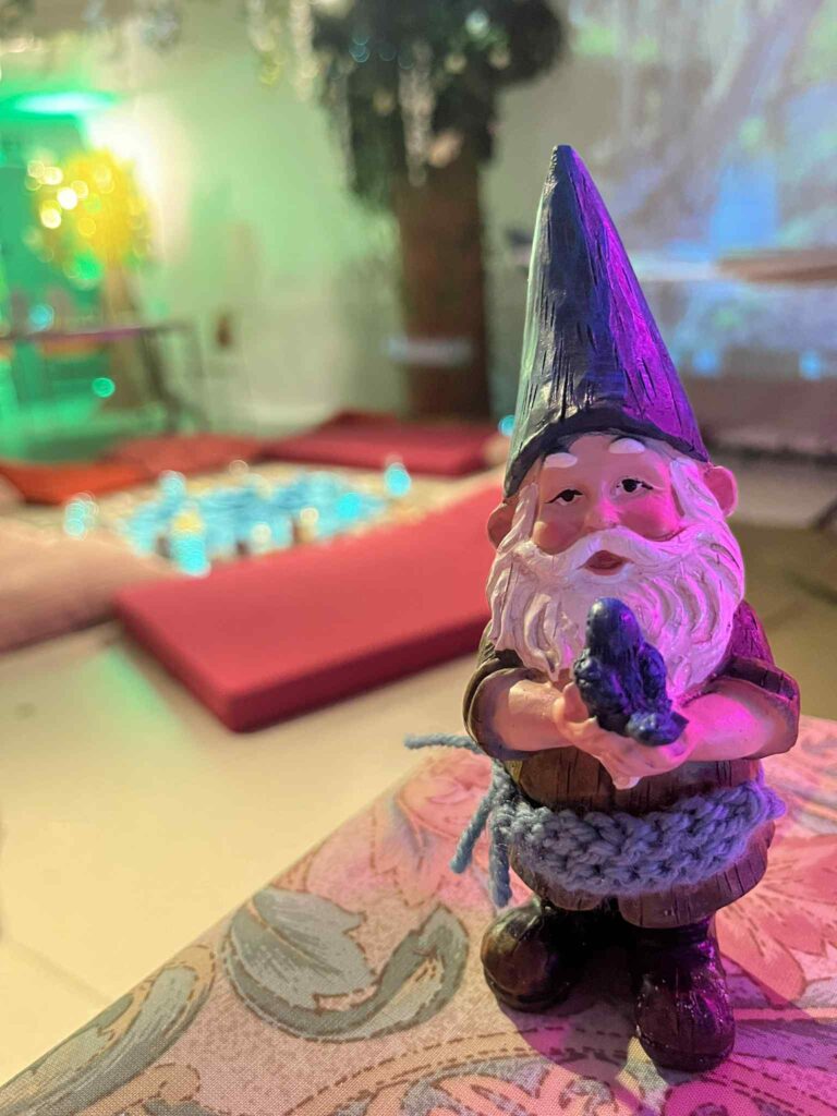 A close up of a small bearded gnome statue holding a bird in the Happy Place installation.