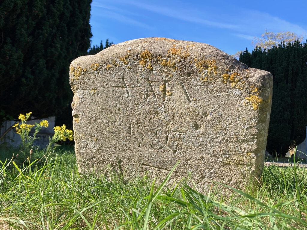 The recently rediscovered footstone marking the grave of Anna Maria Vassa, inscribed ‘A M V / 1797’ in St Andrew’s Churchyard, Chesterton.
