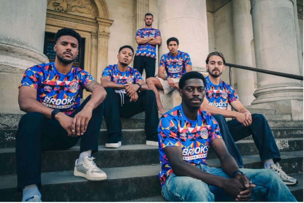 A group of six Cambridge United FC players wearing the new Equiano-inspired shirts on the front steps of the Fitzwilliam Museum.