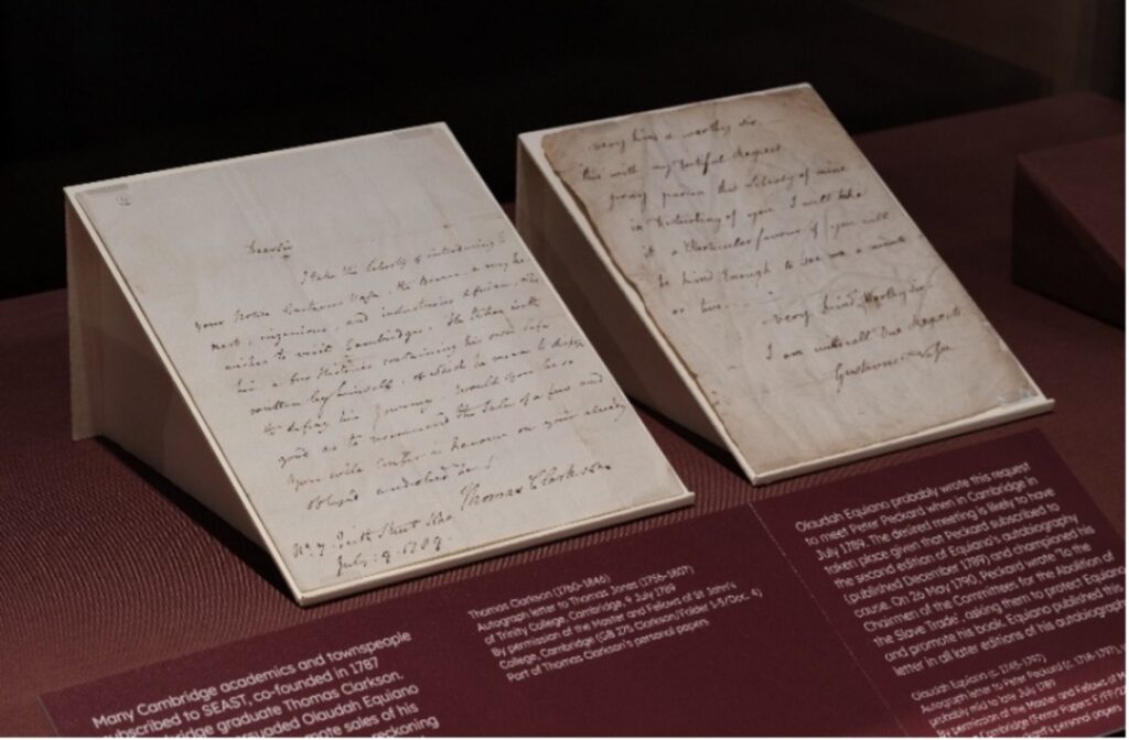 Two handwritten letters in a display case with corresponding labels, both of which share Equiano’s imminent arrival in Cambridge.
