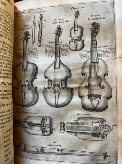 An open book showing a page of drawings of stringed musical instruments.