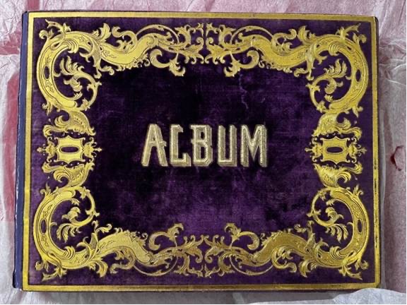A purple velvet book with an elaborate gold border and central gold text reading 'ALBUM'.