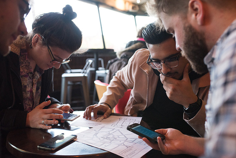 Players around a table look at a map to decide which museums to try first