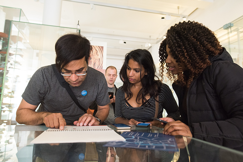 Four people solving a puzzle on the ground floor of the Museum