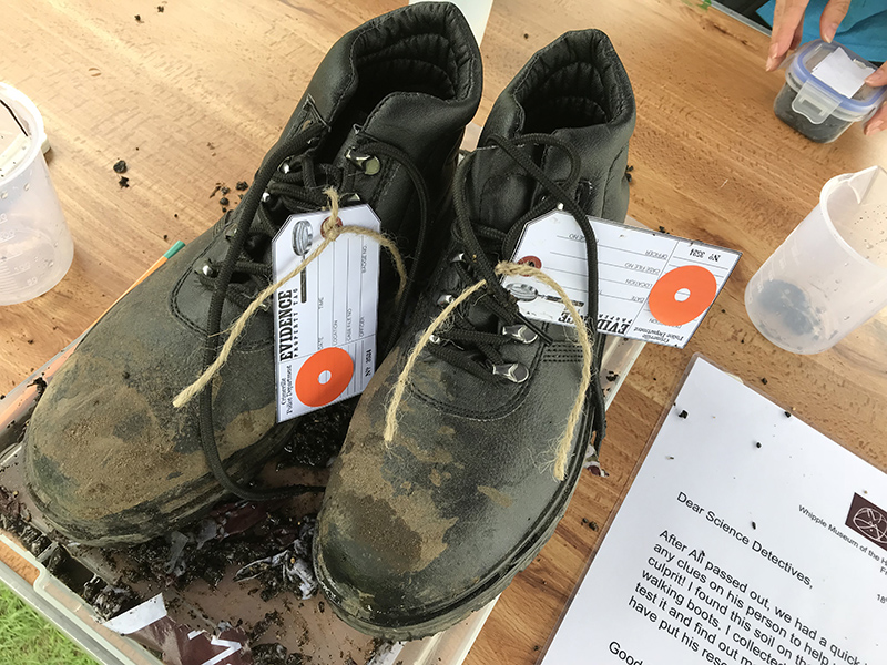 A pair of muddy black boots, labelled as "Evidence"