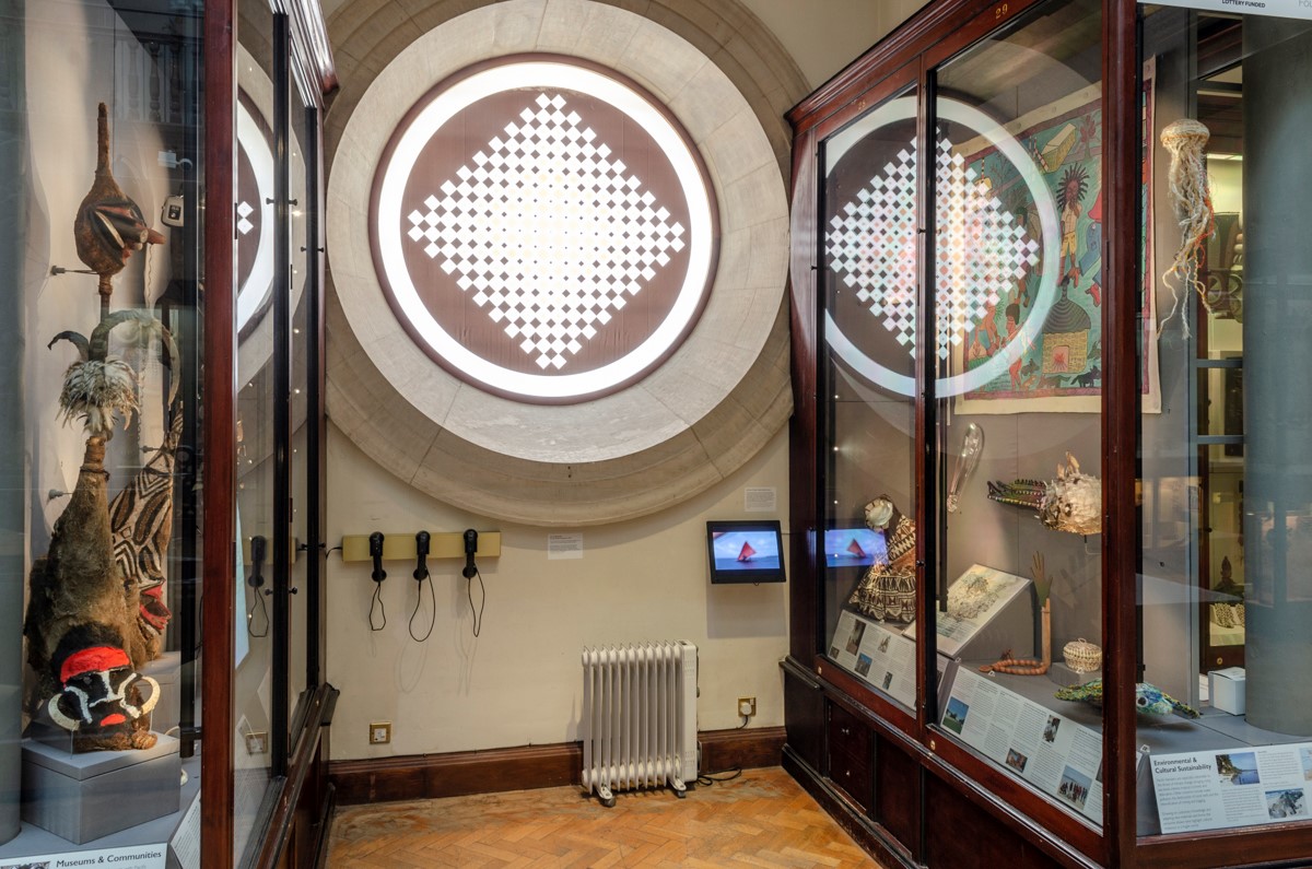 A view of two wooden and glass cabinets containing Pacific artefacts