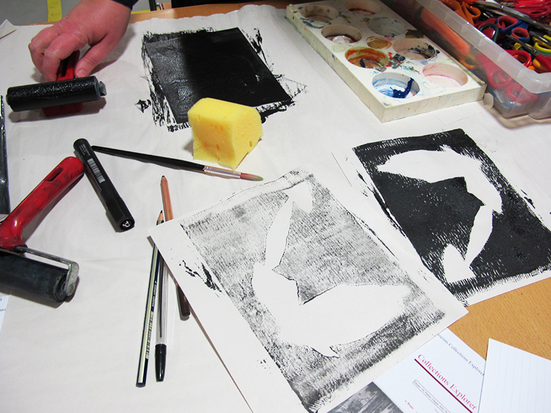 A shot of a worktable in the stdio, with sponges, brushes, and a black and white print in progress