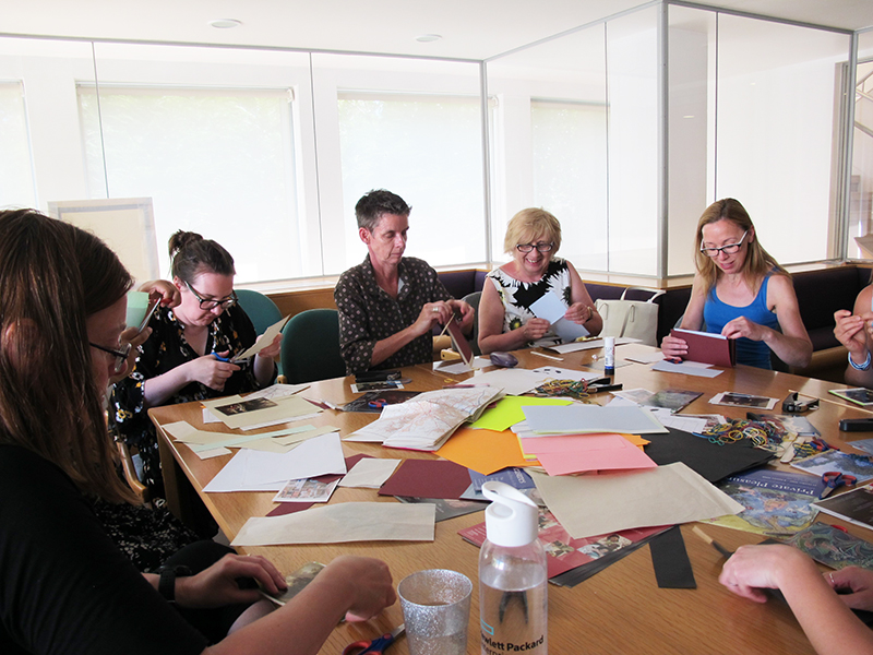 Participants sit around a table making crafts