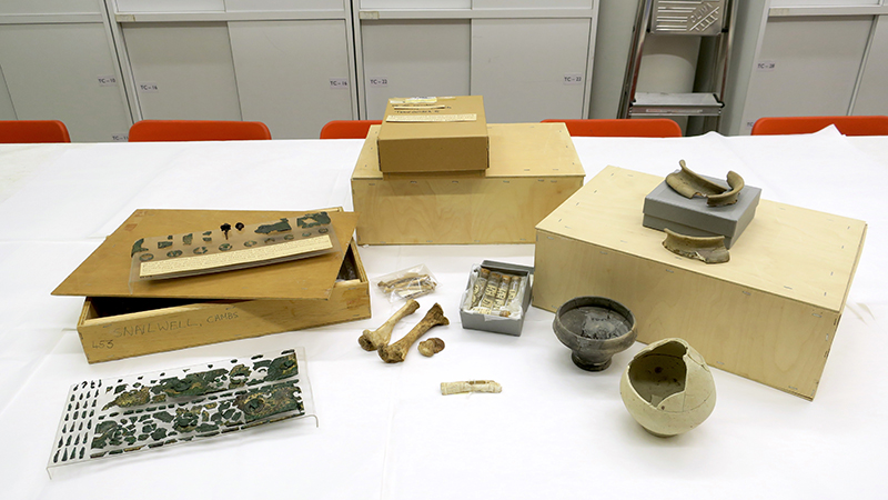 a selection of small finds and boxes laid out on a work bench