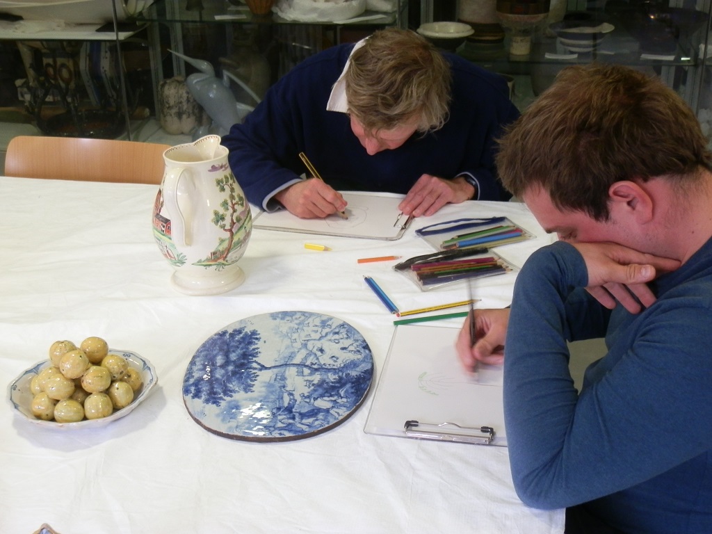 Peter drawing the farmyard jug and Frank drawing the Delftware wall-plaque of coney catching