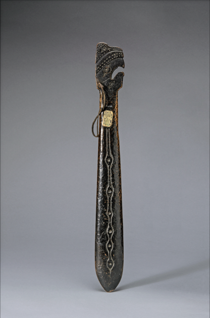 Bronze hand club with incised designs and bird-like head 