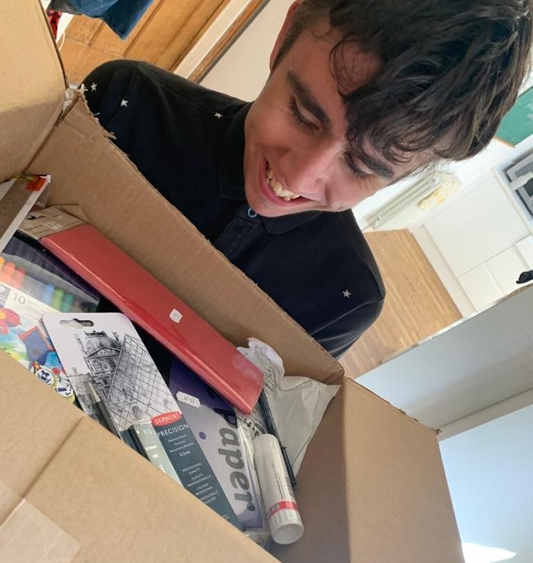 An arts pioneer receiving their box of art supplies