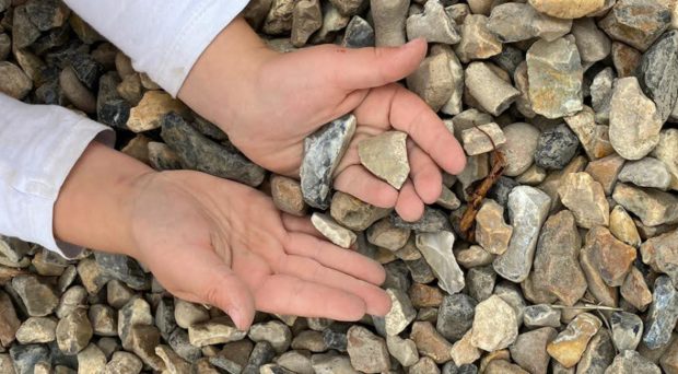 A child holding gravel