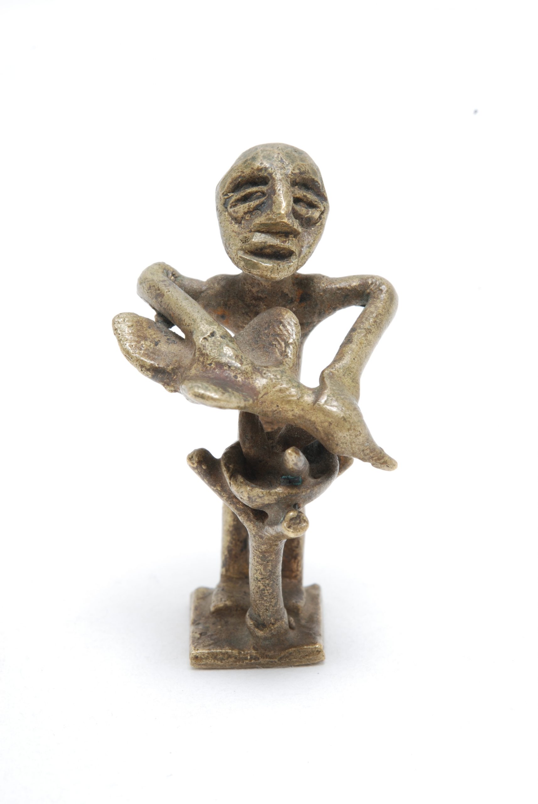 A brass abrammo, or goldweight, depicting a man sacrificing a fowl to Nyame at the Nyame Dua, which has a bowl containing three eggs in its fork.