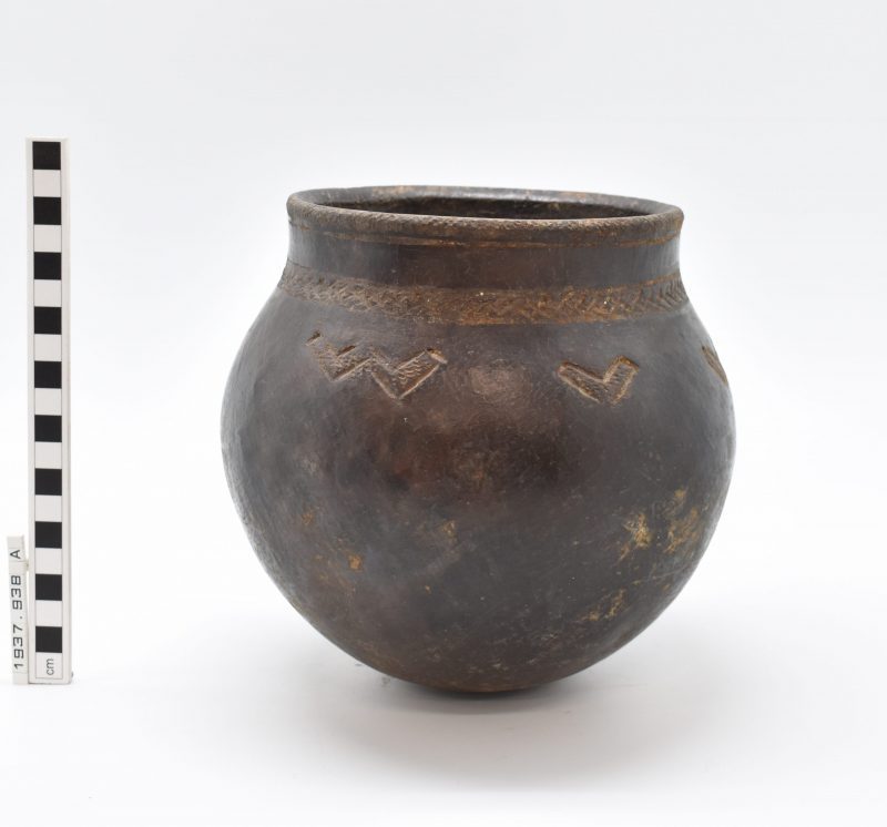 A dark brown, rounded ceramic vessel with W and V shaped markings