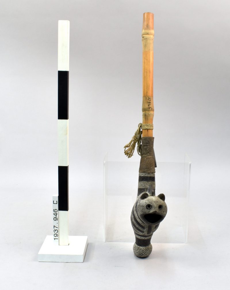 A zoomorphic pipe with a cat-shaped bowl and wooden stem.