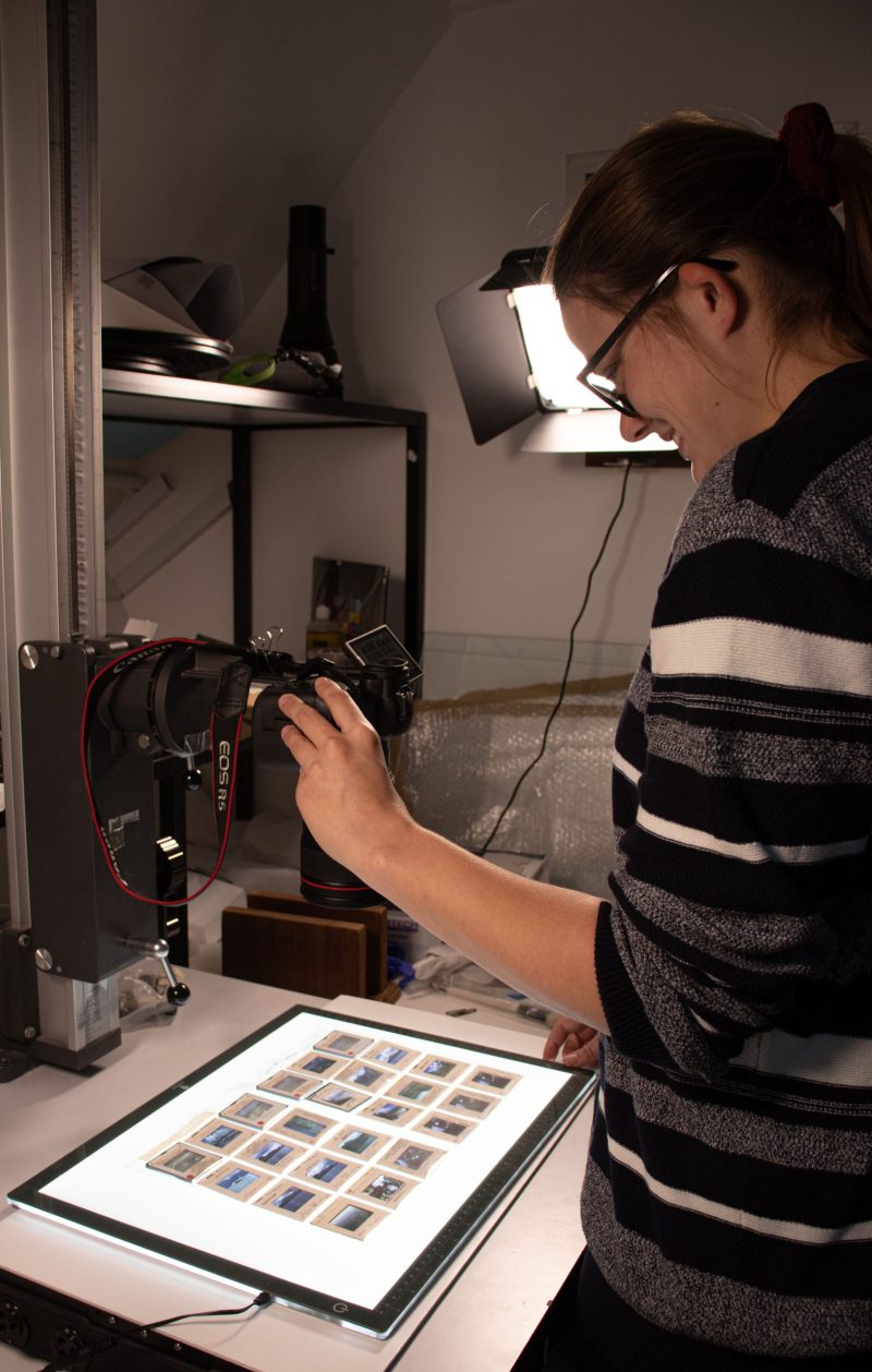 Woman photographing a sheet of transparencies using a digital camera