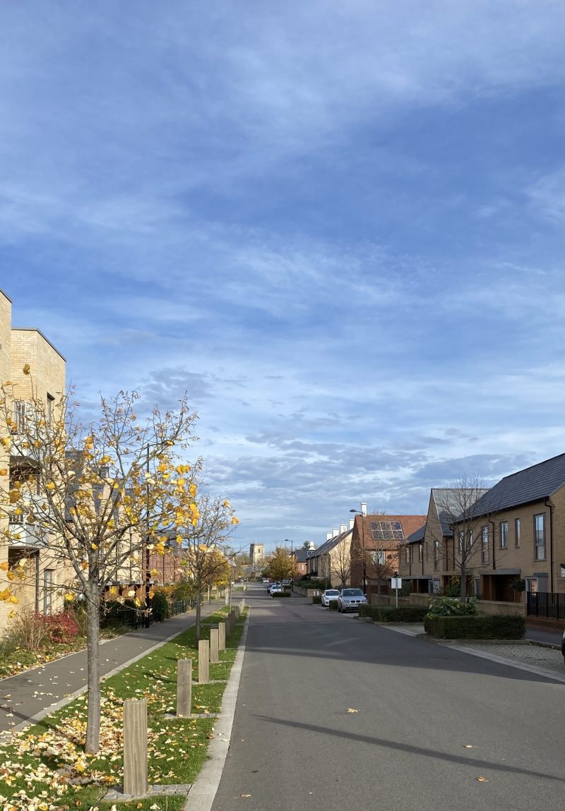 Road with new housing and church visible in bakground.