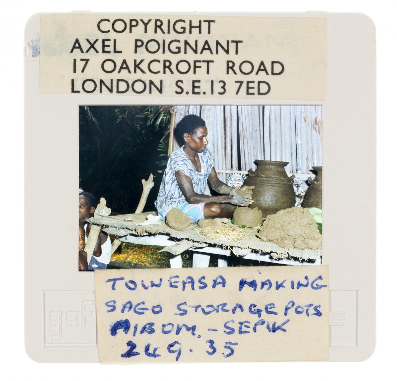Transparency of woman sitting on making pots. The border of the transparency is labelled and marked with copyright details.
