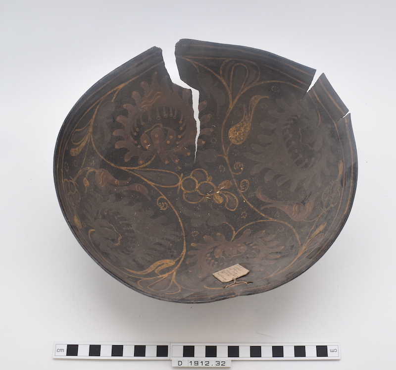 Dark brown gourd bowl with decorative markings and a crack running from the top to the middle.