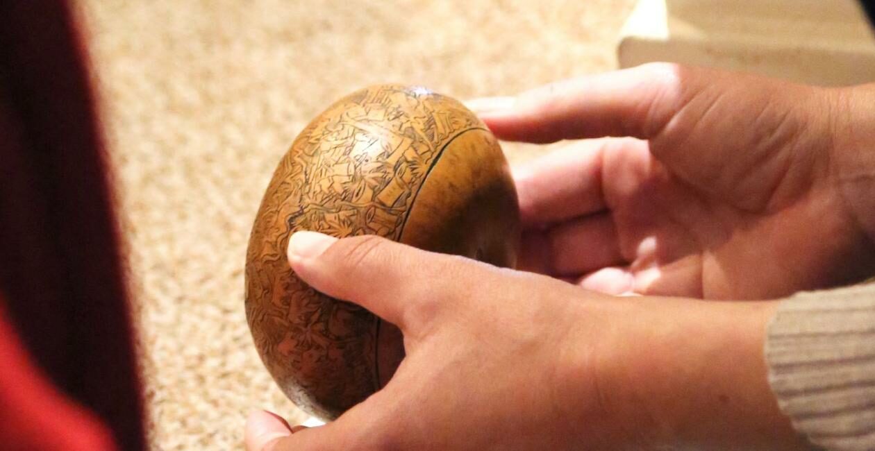Pair of hands holding a small wooden globe