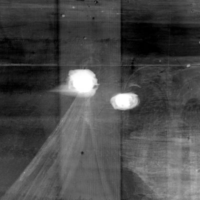 Section of x-ray of Cupid & Psyche showing some filler. The filler is in two circles and appears white against the dark wood and painting.