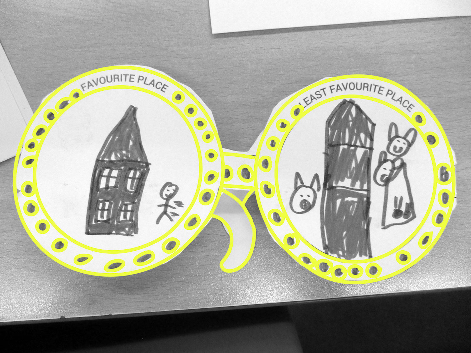 A pair of Empathy glasses made to of paper with a drawing on each lens, one is their favourite place and the other is their least favourite place. 