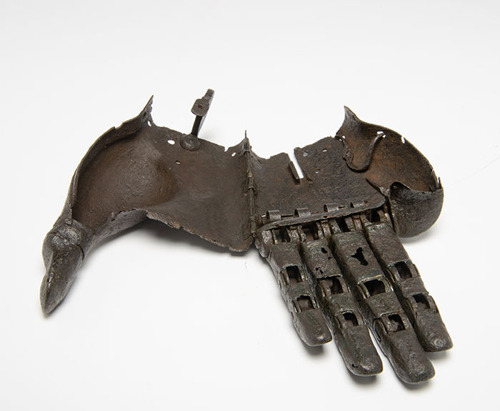 iron prosthetic hand open at the hinges to reveal the hollow inside of the hand, the hook for fastening it shut, and the articulated fingers.