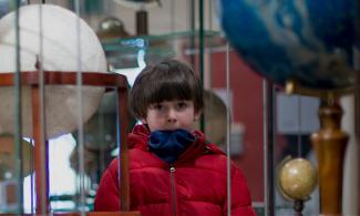 Child surrounded by multiple globes 