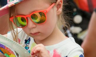 Child with ammonite reflecting in her sunglasses