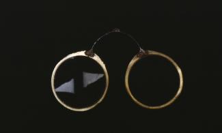 spectacles with round lenses against a black backgriund