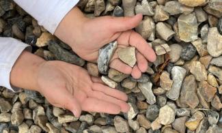 childs hands and gravel