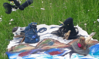 Selection of felted objects displayed on a grass lawn