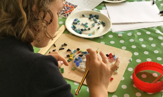 Child using mosaic tiles for craft