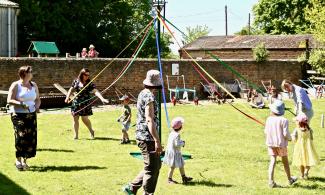 Children dancing round a traditional maypole