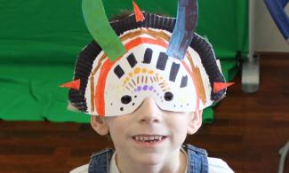 Child wearing decorated mask based on fossil shapes