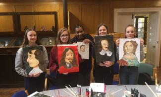 4 children and artist holding self-portraits
