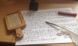 Old fashioned writing and printing equipment including ink, quill, paper and wax