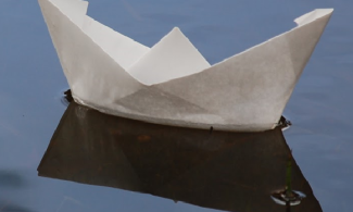 Paper boat floating on water