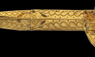 A gold dagger sheath with turquoise and lapis lazuli inlays