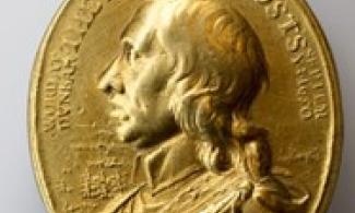 Gold medal depicting the head and shoulders of a man