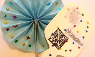 2 paper fans decorated with sequins and small stickers