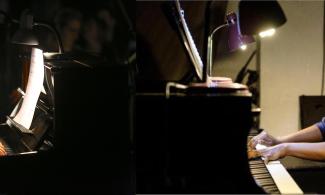 two pianists playing in a darkened room
