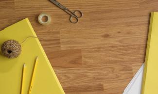 Yellow paper, scissors and string on a wooden table