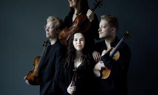 4 musicians in a shadowy background