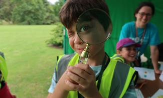 Child looking into a magnifying glass