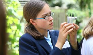 Student looking closely at a plant