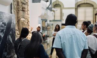 Museum educator talking to an audience about an object from Mayan culture